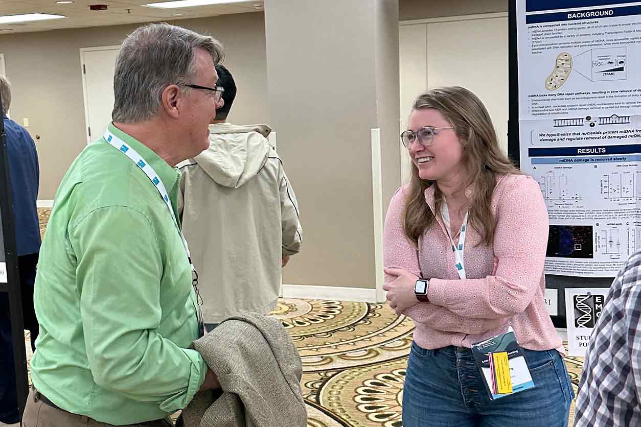 NIEHS grantee Bennett Van Houten, Ph.D., left, chats with Dillon King, Ph.D., right,